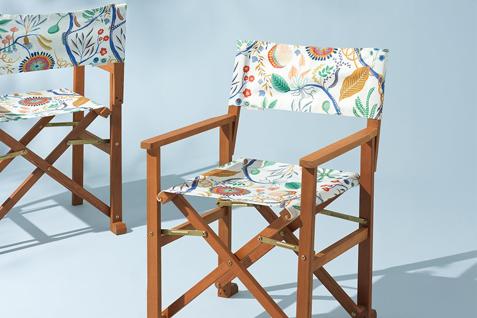 Scion x Hbaitat garden umbrella and deck chair in white floral pattern next to garden planter with green plants.