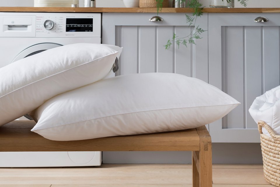 Pillows stacked on wooden bench.