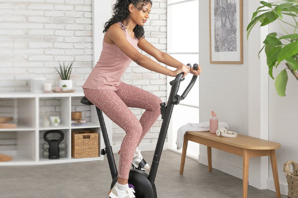 A woman exercising on an Opti manual exercise bike.