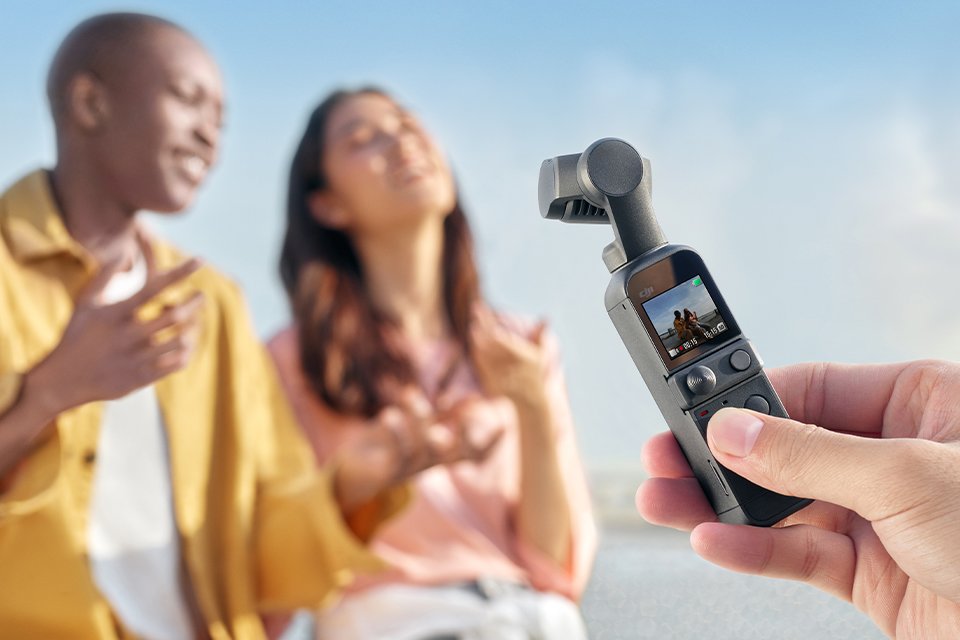 A group of friends taking photographs at the beach with the DJI Pocket 2 handheld camera. 