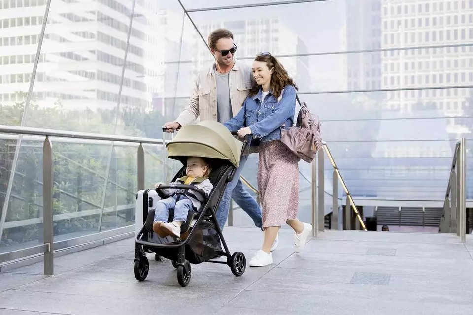 A couple pushing their toddler in a Graco Myavo Lightweight Stroller - Mint.