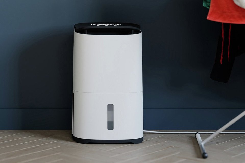MeacoDry Arete Two 25L Dehumidifier and Air Purifier placed in a laundry room under a clothes airer. 