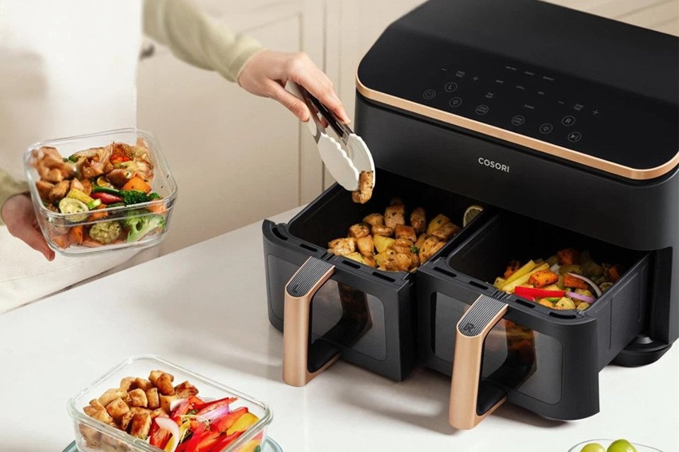 COSORI A woman using Dual Basket CAFR903AUK 8.5L Air Fryer - Black.