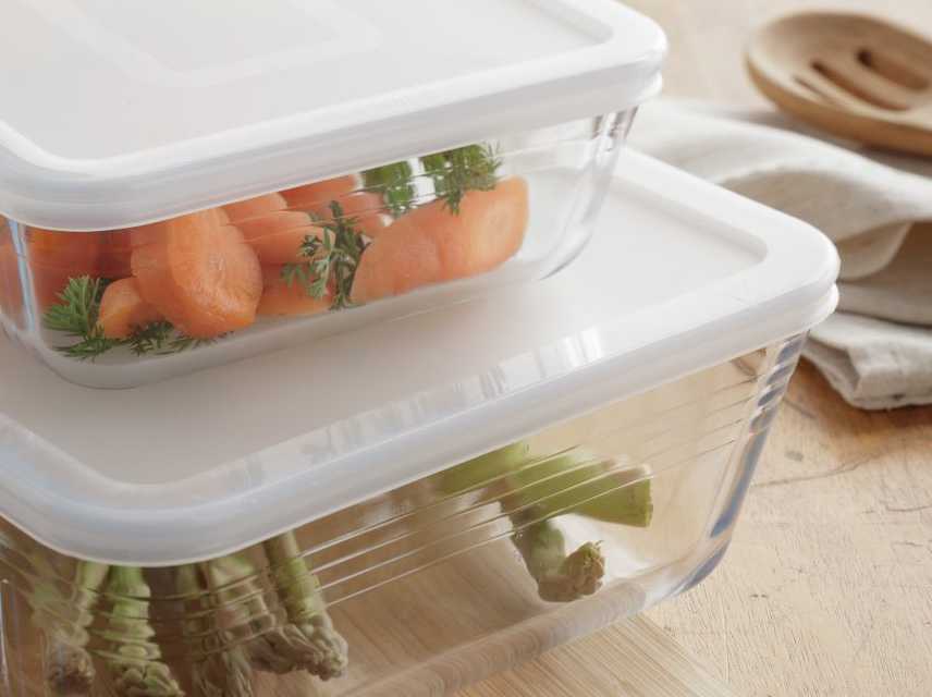 Glass oodcontainers on kitchen side with food stored.