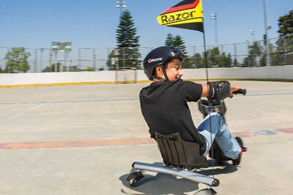 A young boy riding a Razor PowerRider 360 electric tricycle ride-on.