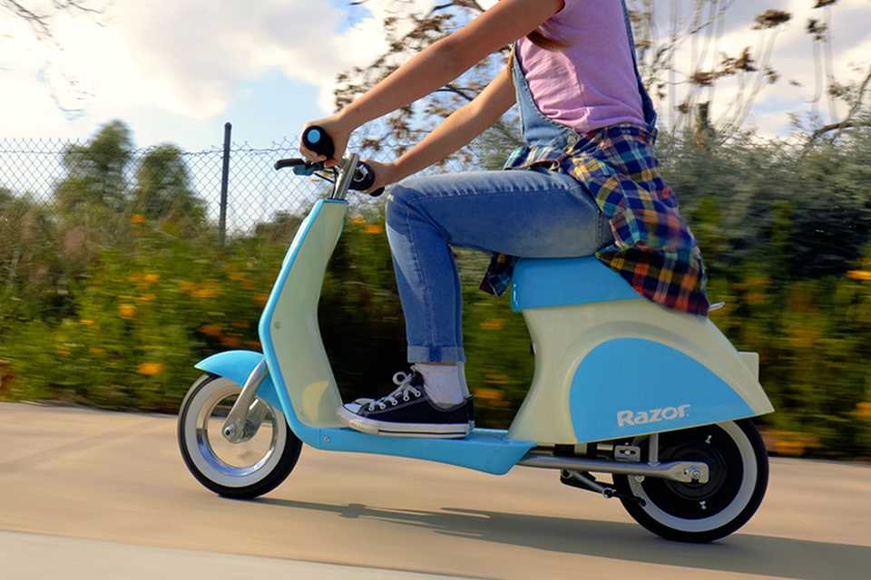 A boy riding a Razor Pocket Mod Petite electric scooter.