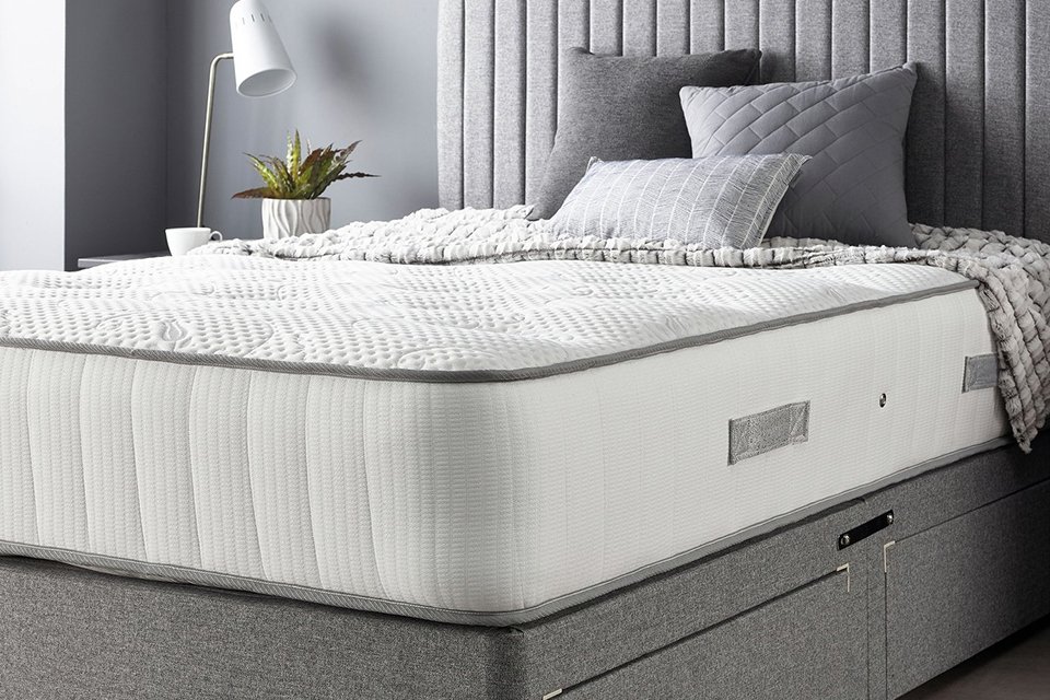 A bed with a white mattress on top of it.
