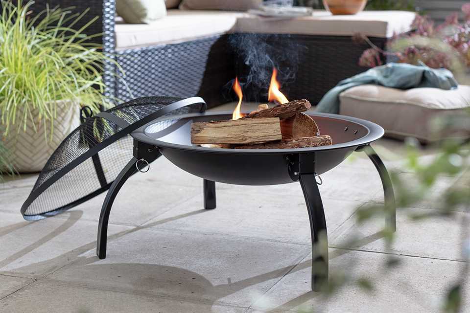 A metal fire pit with burning logs.
