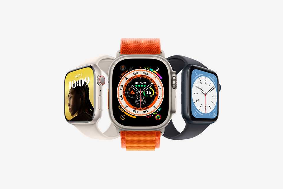 An assortment of Apple Watches clustered together, including: Apple Watch Ultra, Apple Wacth Series 8, and Apple Watch SE.