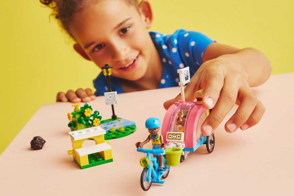 A young boy playing with a LEGO® Dog Rescue Bike toy and playset.