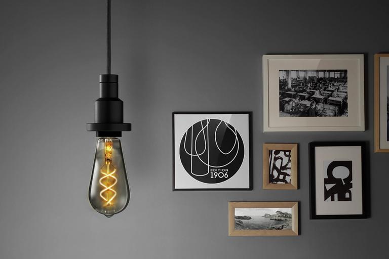 Image of an Edison style hanging from a ceiling in a grey room.