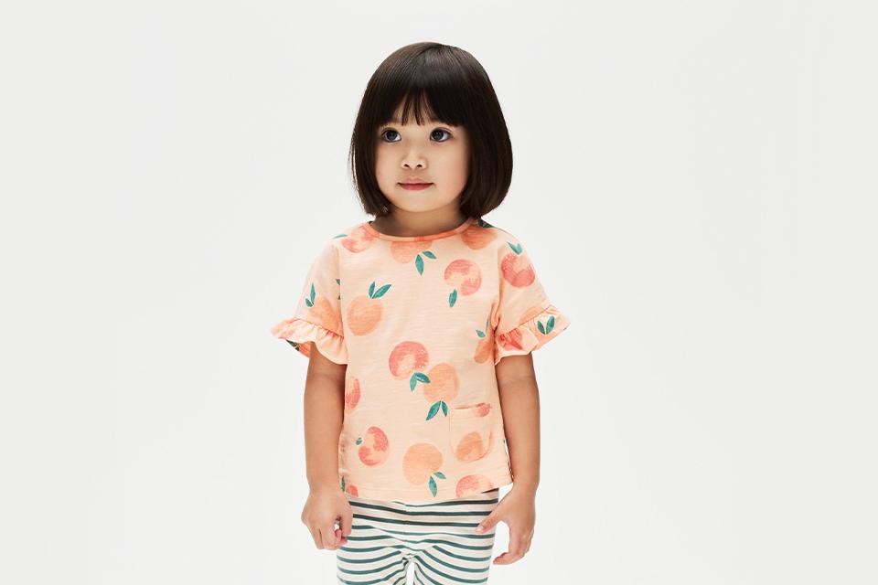 Young girl in peach printed t-shirt.
