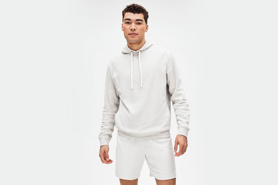 Male model in grey jersey hoodie and matching shorts. 