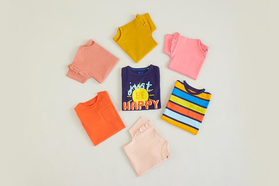 Selection of colourful printed kids' t-shirts in a circle layout. 