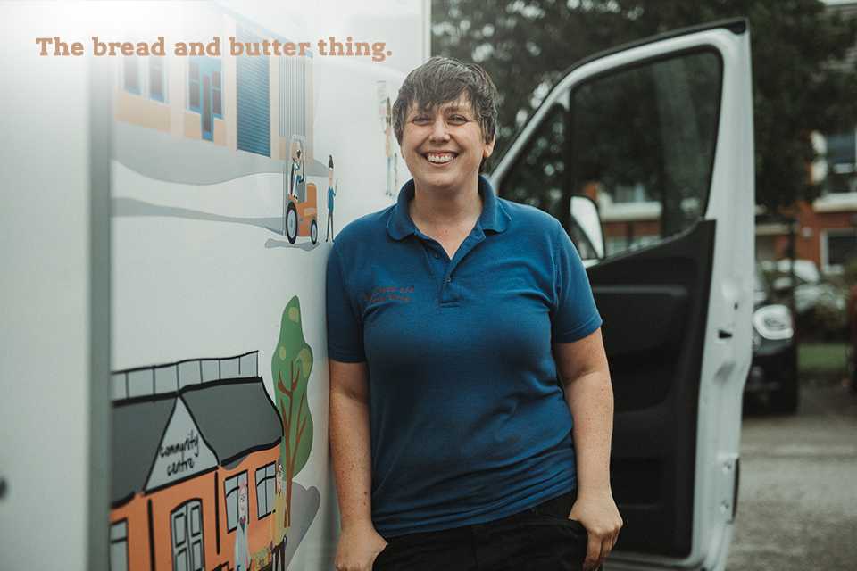 A female volunteer standing next to a van.