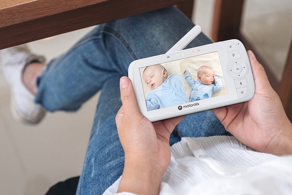 A mother checking her baby through a Motorola Nursery VM35 2 video monitor.
