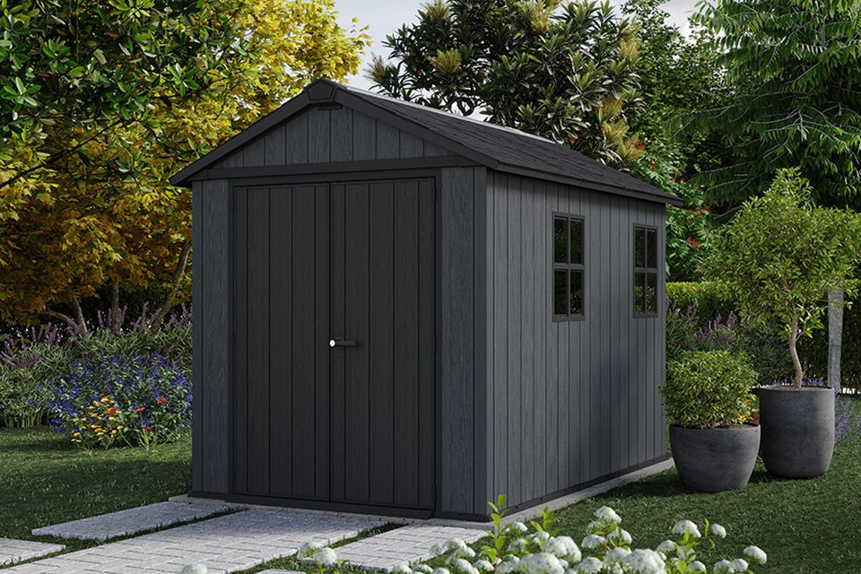 Keter Newton Plus Plastic shed surrounded by trees and plants.