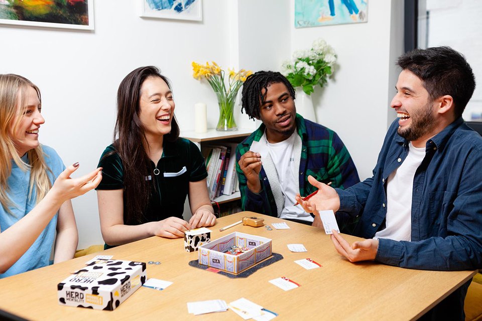 A group of friends playing Big Potato Herd Mentality Moosic & Moovies Family Card Game.