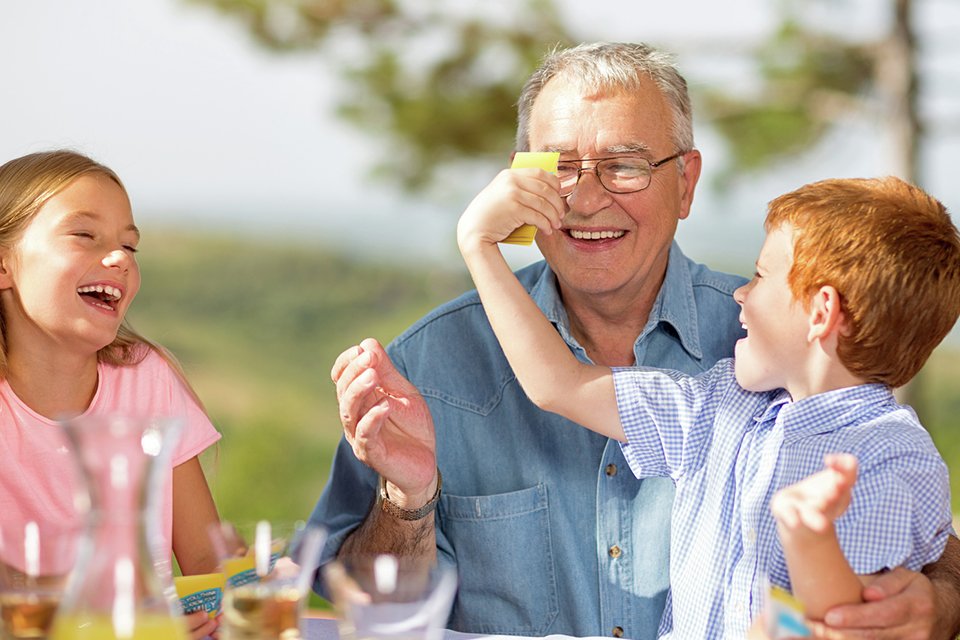 Two kids playing Moose Do You Really Know Your Family Board Game with their grandfather.