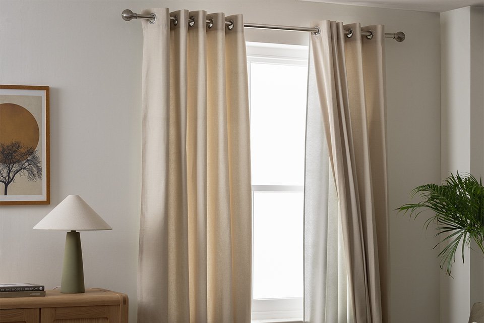 Argos Home white eyelet curtains in a living room.