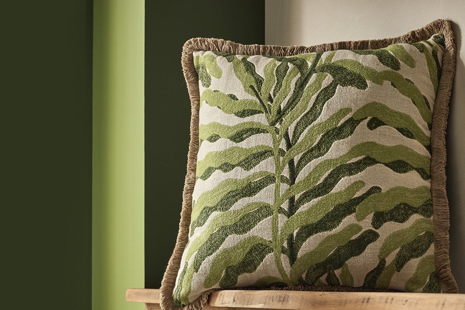 A Habitat leaf green jacquard cushion in a living room.