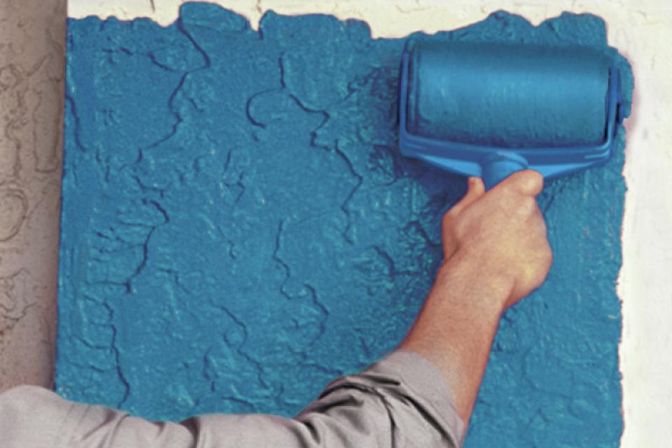 Person painting a wall blue.