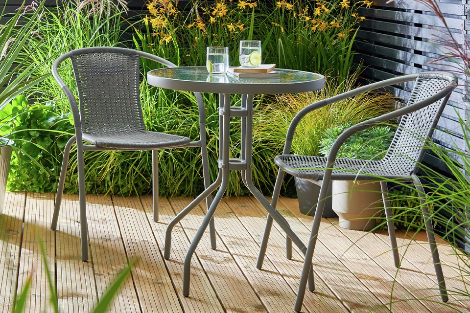 An Argos Home 2-seater rattan effect garden bistro set on a balcony.