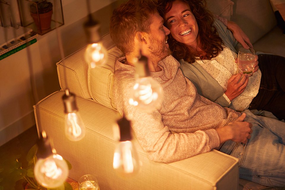 A couple sitting in a living room with LED lights on.