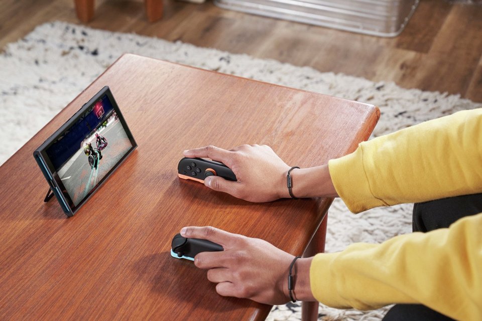 A person using a Nintendo Switch 2 console in black with blue and red joy-con controllers.