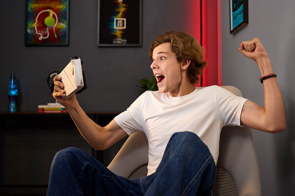 Gamer looking excited while playing a game on his device. 