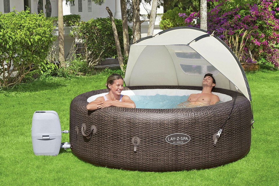 A couple relaxing in a hot tub with Lay-Z-Spa detachable hot tub canopy over it.