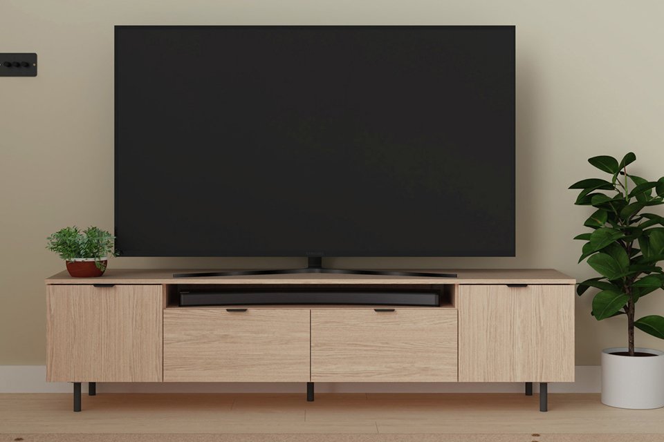 A natural Argos Home Taite 2 door 2 drawer TV unit in a living room.