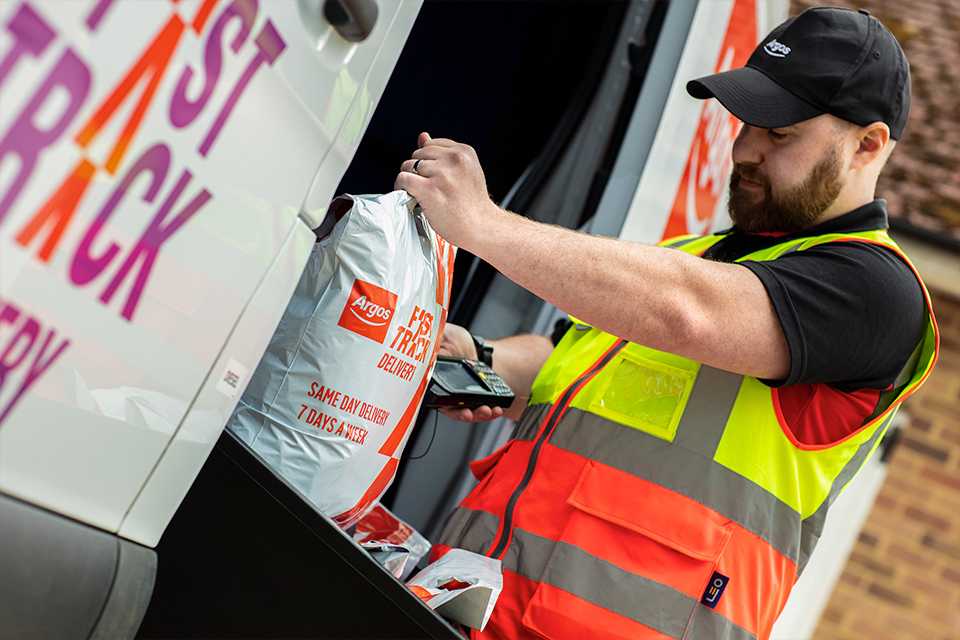 An Argos driver scans a Fast Track package.