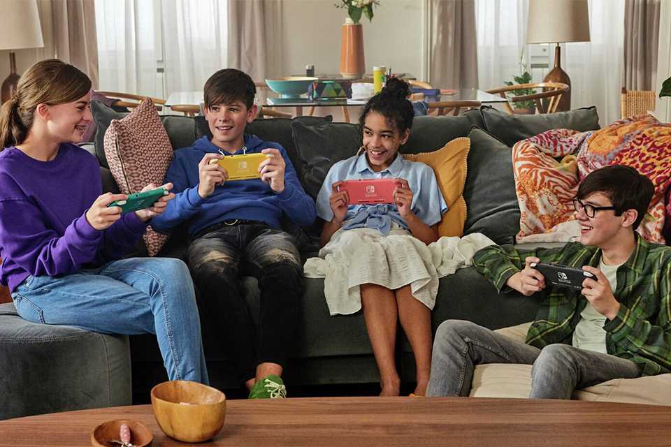 A group of kids playing with Nintendo Switch lite handheld console.