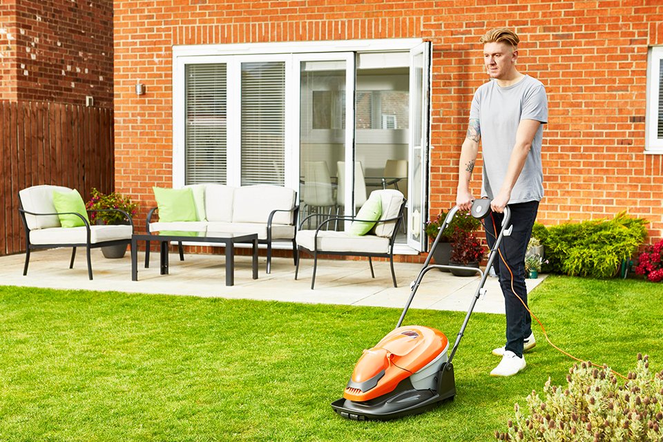 A man mowing a lawn with a Flymo® EasiGlide hover lawnmower.