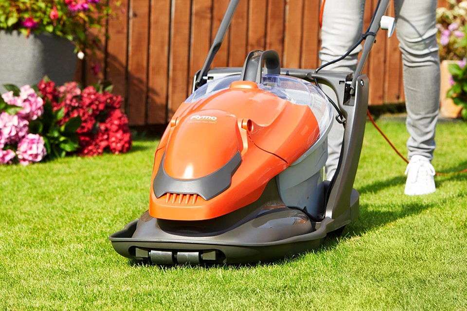 A man mowing a lawn using a Flymo® EasiGlide lawnmower. 
