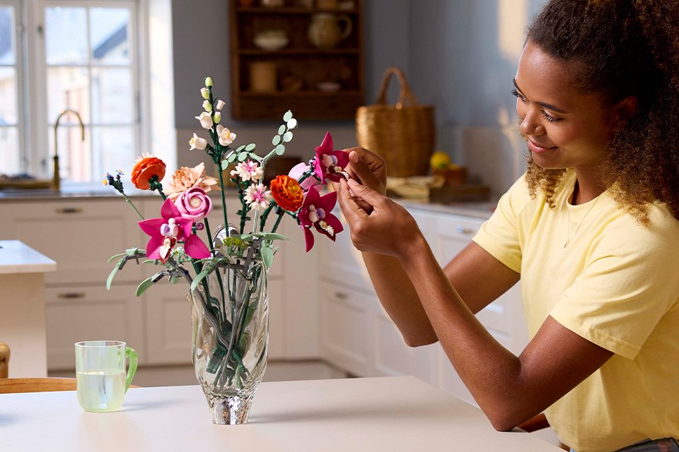 A woman building LEGO® flowers.