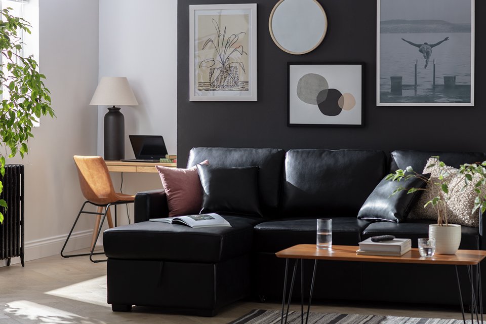 A Habitat Reagan LH Faux Leather Storage Sofa Bed in an open living space.