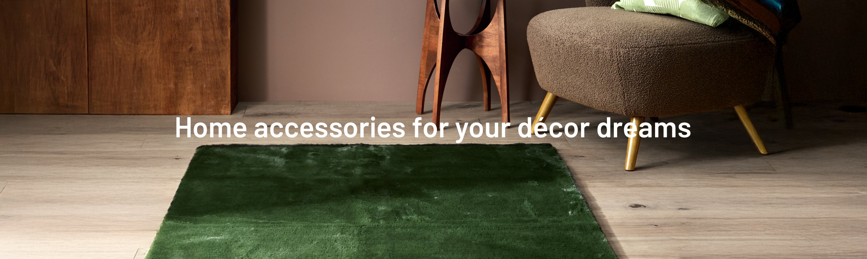 A Habitat Cosy Soft Moss Green Short Pile Rug placed in front of an armchair and wooden side table.
