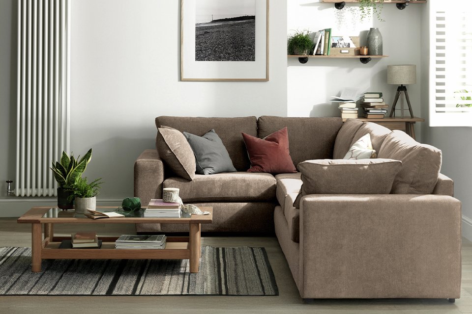 A Habitat Elmdon Fabric Left Hand Corner Sofa in front of a coffee table in a living room.