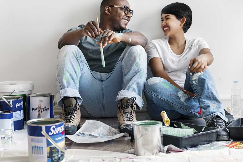 A couple having fun while painting their house.