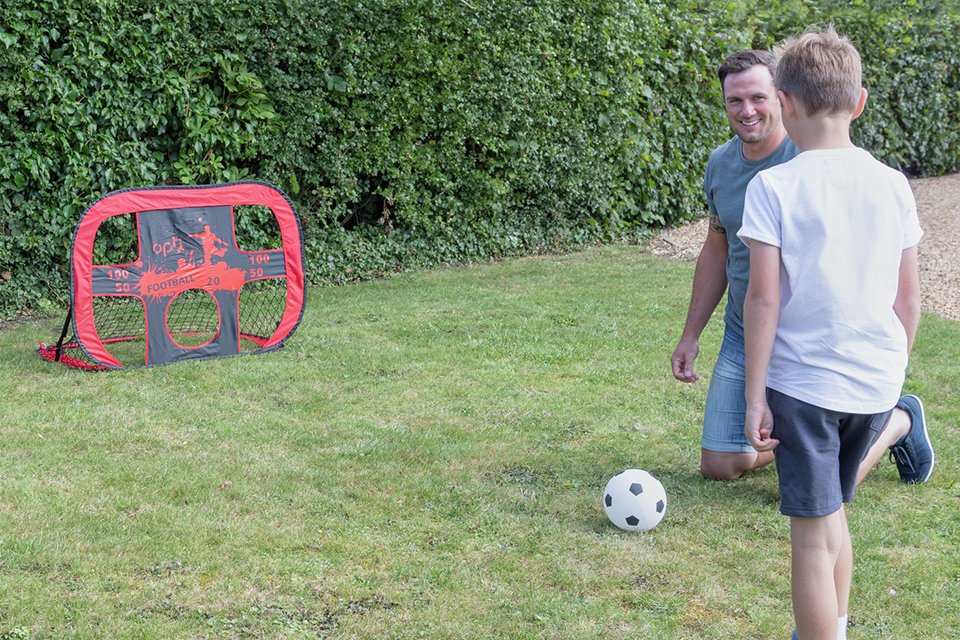 Man and boy playing in a garden with Opti 3.5 x 3ft 2 in 1 Pop Up Target Training Football Goal