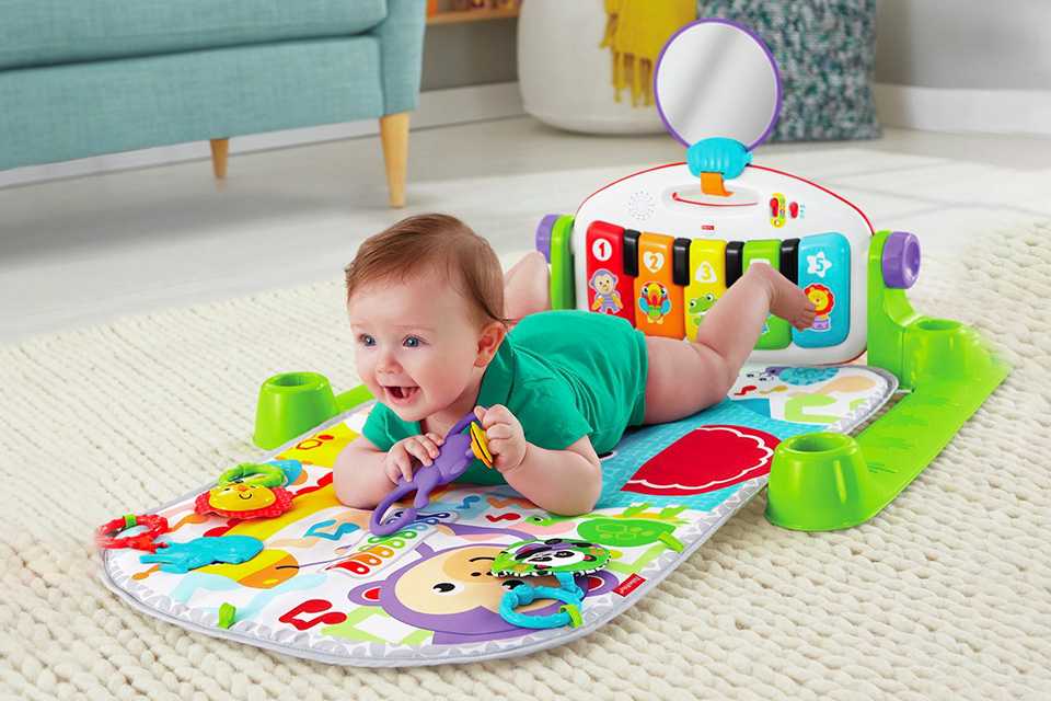 A baby rolled over on his tummy on a playmat.