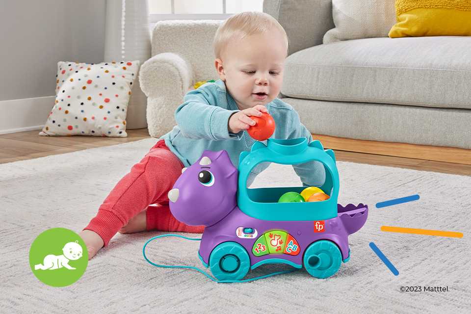 A toddler playing with a Fisher-Price Poppin' Triceratops learning activity toy.
