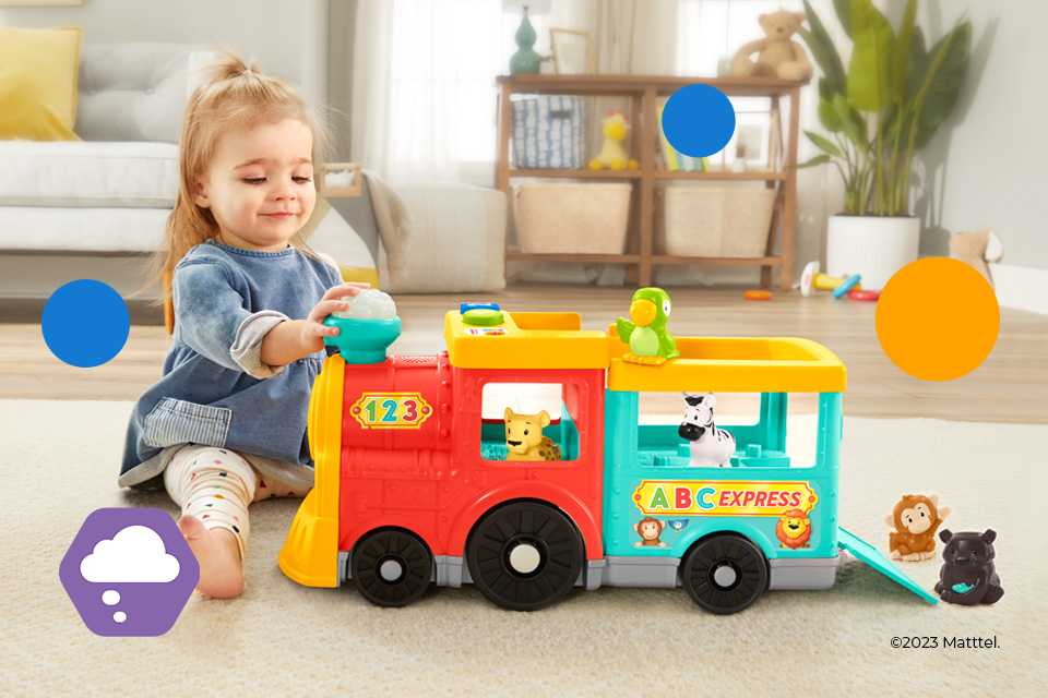 A baby girl playing with a Fisher-Price Little People Big ABC Animal Train toy.