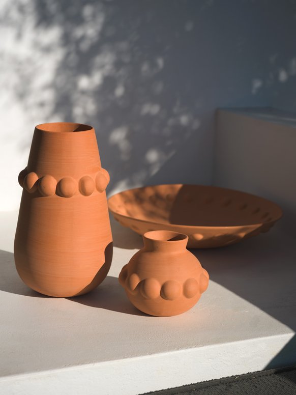 2 Habitat terracotta vases and a terracotta bowl placed outdoors.