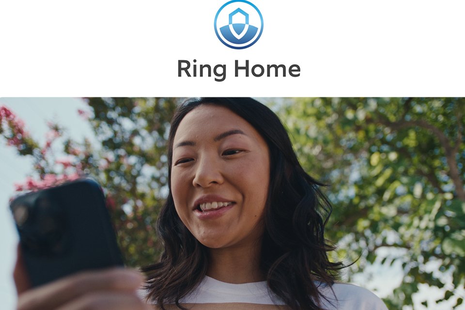 A woman smiling while looking at her mobile whilst Ring Home safety symbol is on top of the picture.