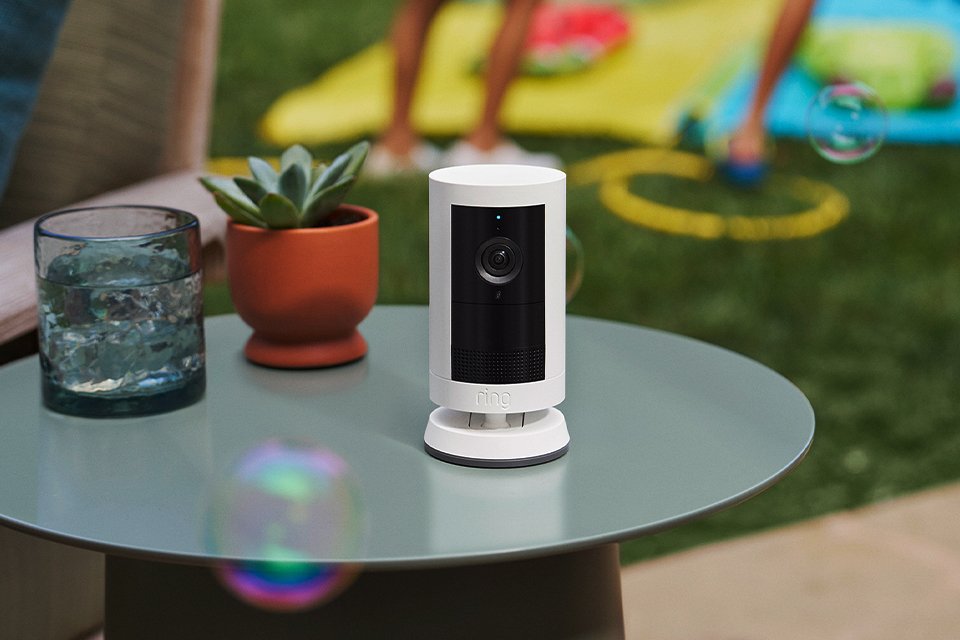 A white Ring Outdoor Camera Plus placed on an outdoor table.