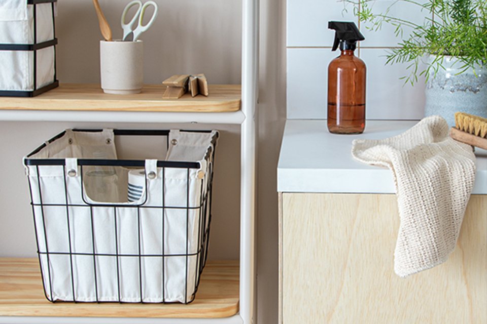 A white Habitat 36 Litre storage basket placed in a shelving unit next to other everyday essentials.