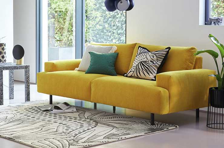 A yellow sofa in a living room.